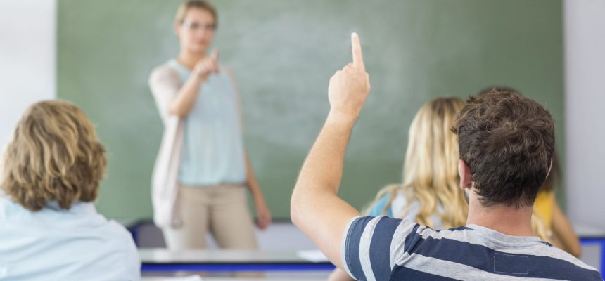 Male student raising hand in the classroom